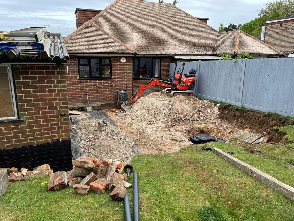 Mini excavator digging a backyard foundation trench