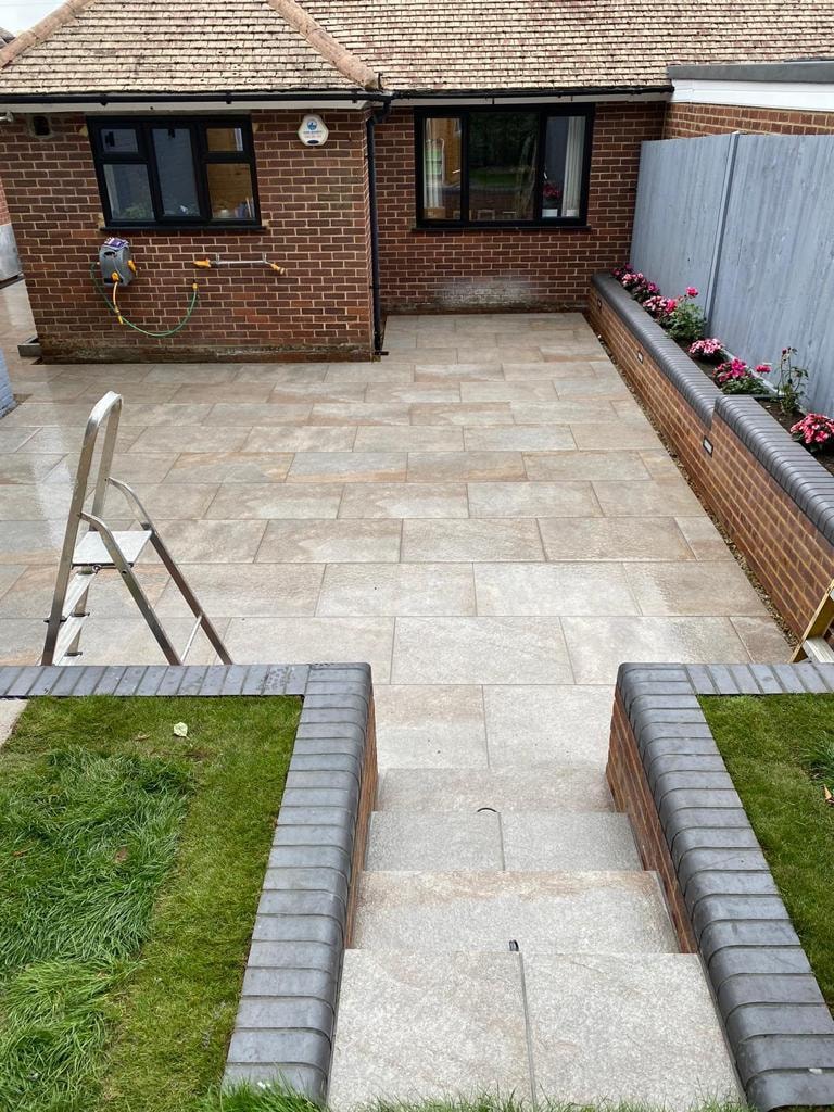 Paved courtyard with flower beds and brick steps