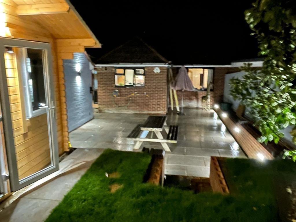 Paved backyard patio with wooden garden cabin